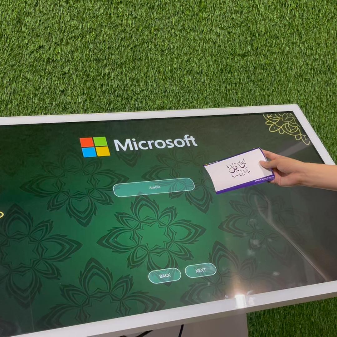 Guest receiving printed Arabic calligraphy artwork at a live event in Dubai, showcasing AI-powered personalized calligraphy in an elegant cultural setting.